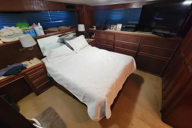 Slide: The Image of Cozy bedroom in 1982 Hatteras 56 Wide Body yacht with wood paneling and a TV. - 33