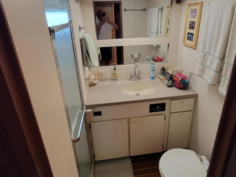 Slide: The Image of 1982 Hatteras 56 Wide Body yacht bathroom with shower, sink, and storage cabinets. - 36