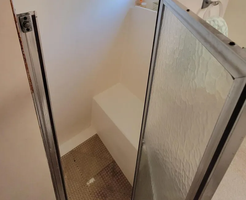 Slide: The Image of Shower area inside 1982 Hatteras 56 Wide Body yacht, featuring glass door and white interior. - 37