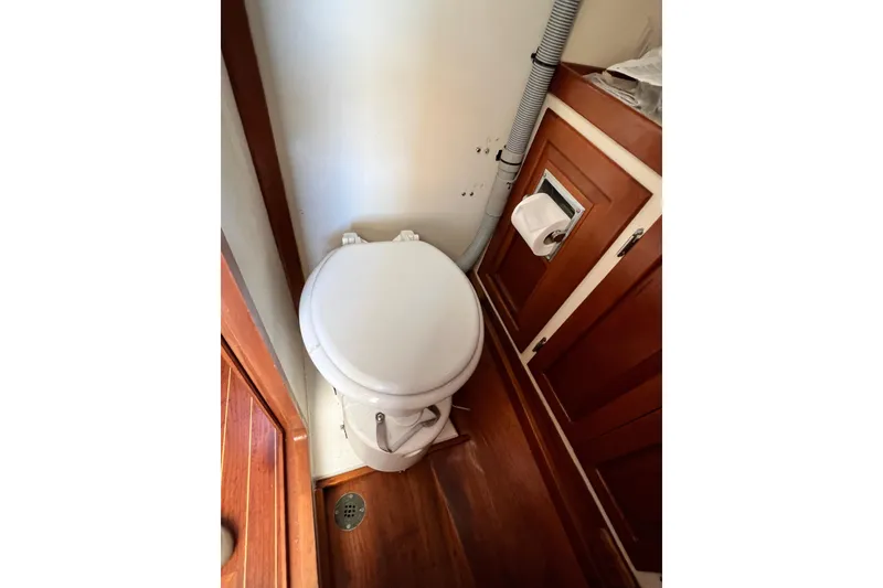 Slide: The Image of 1988 Jarvis Newman HARDTOP CRUISER bathroom with wooden cabinetry and compact toilet. - 10