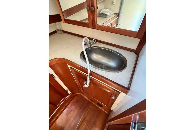 Slide: The Image of 1988 Jarvis Newman Hardtop Cruiser bathroom with wooden cabinetry and stainless steel sink. - 11