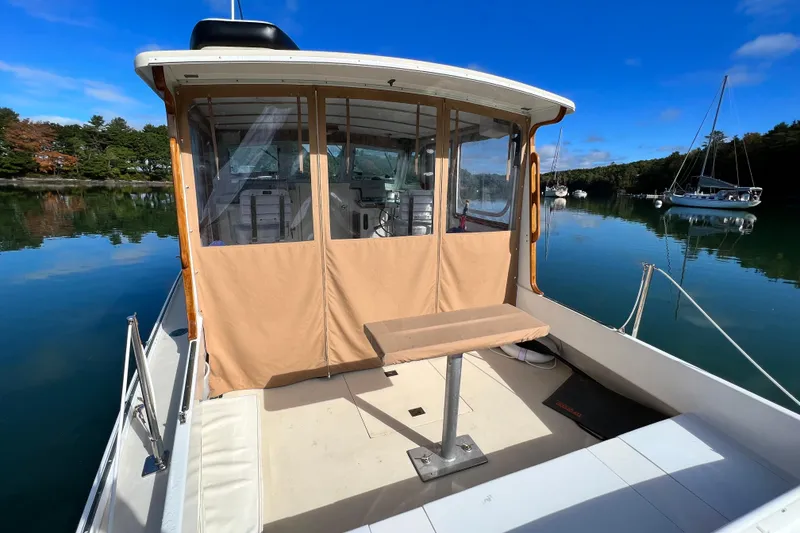 Slide: The Image of 1988 Jarvis Newman Hardtop Cruiser on calm water, featuring a covered deck and scenic surroundings. - 13