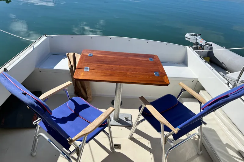Slide: The Image of 1988 Jarvis Newman Hardtop Cruiser deck with wooden table and blue chairs. - 15