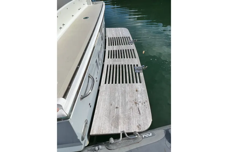 Slide: The Image of 1988 Jarvis Newman HARDTOP CRUISER swim platform with metal cleats, docked on calm water. - 19