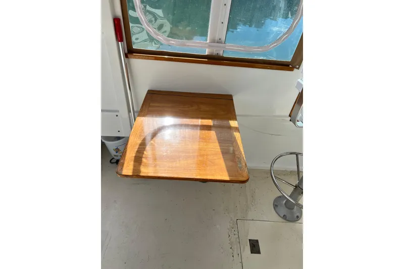 Slide: The Image of 1988 Jarvis Newman HARDTOP CRUISER interior with wooden table and window view. - 3