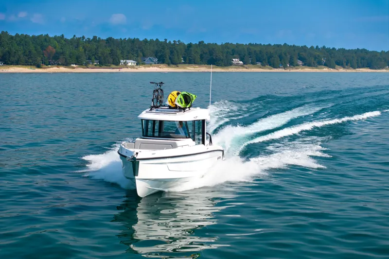 Slide: The Image of 2026 Cruisers Yachts 38 VTR speeding on a scenic lake with forested shoreline. - 25