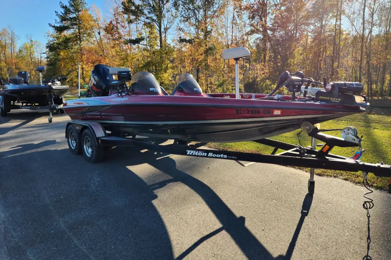 Slide: The Image of 2002 Triton Tr-20 ProDeck boat on trailer, parked outdoors in autumn setting. - 1