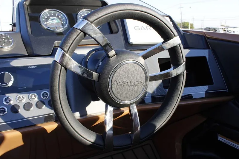 Slide: The Image of Steering wheel of 2026 Avalon Catalina Quad Lounger 27 FT boat, featuring modern dashboard controls. - 23