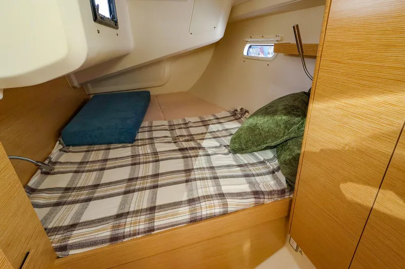 Slide: The Image of Cozy cabin interior of 2022 Hanse 388 yacht with plaid bedding and pillows. - 10