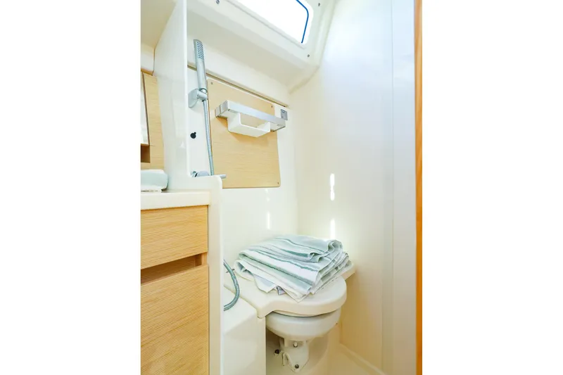 Slide: The Image of 2022 Hanse 388 yacht bathroom with toilet, towels, and natural light. - 15