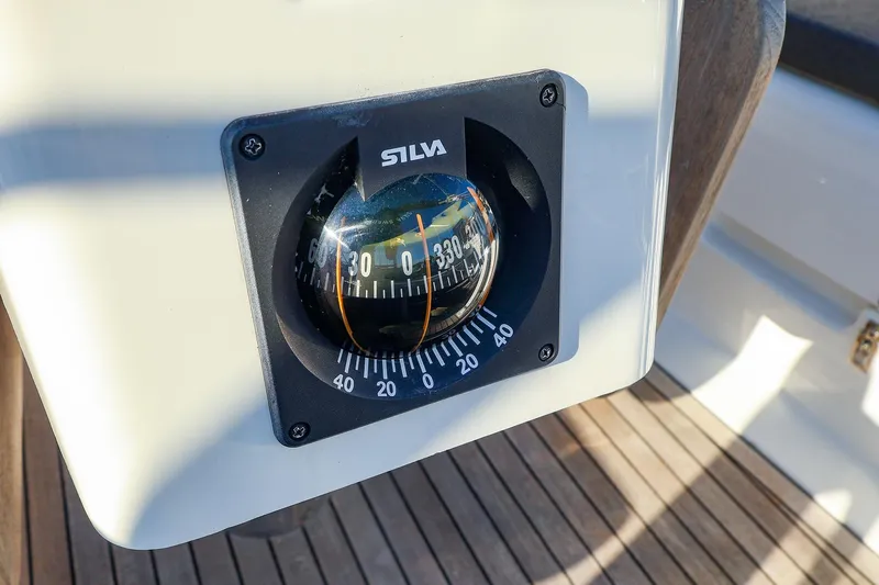 Slide: The Image of Compass on 2022 Hanse 388 yacht, displaying navigation degrees, mounted on wooden deck. - 23