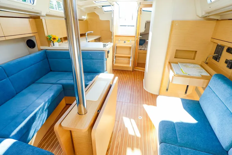 Slide: The Image of Luxurious 2022 Hanse 388 yacht interior with blue seating and wooden accents. - 6