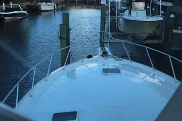 Slide: The Image of 1996 Ocean 53 Super Sport yacht docked in a serene marina setting. - 14