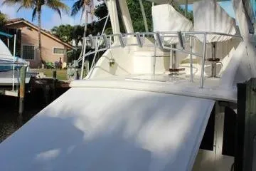 Slide: The Image of 1996 Ocean 53 Super Sport yacht docked near palm trees and a house. - 21