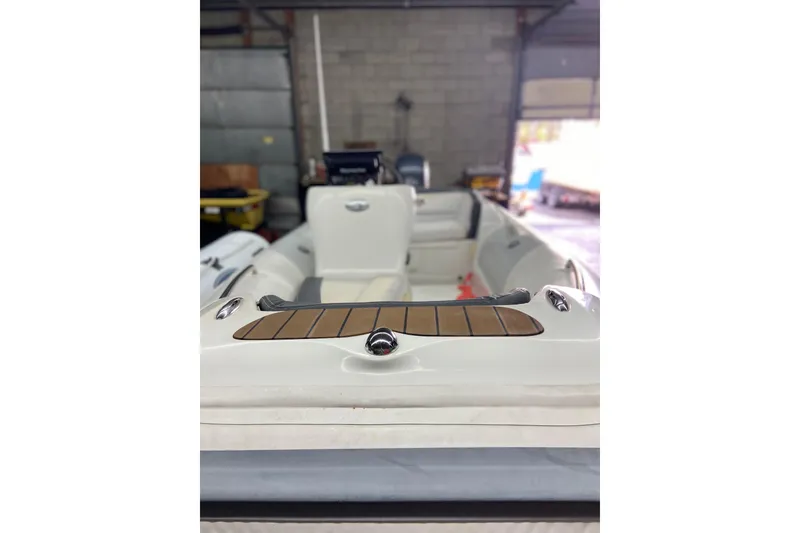 Slide: The Image of 2011 Walker Bay Generation 390 boat interior with seating and wooden accents in a garage. - 5