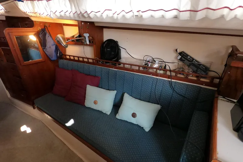 Slide: The Image of Interior of a 1978 Catalina 30 sailboat with blue cushioned seating and wooden accents. - 14