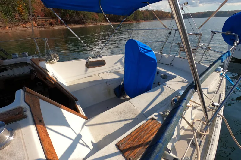 Slide: The Image of 1978 Catalina 30 sailboat cockpit with blue covers, docked on a calm lake. - 5