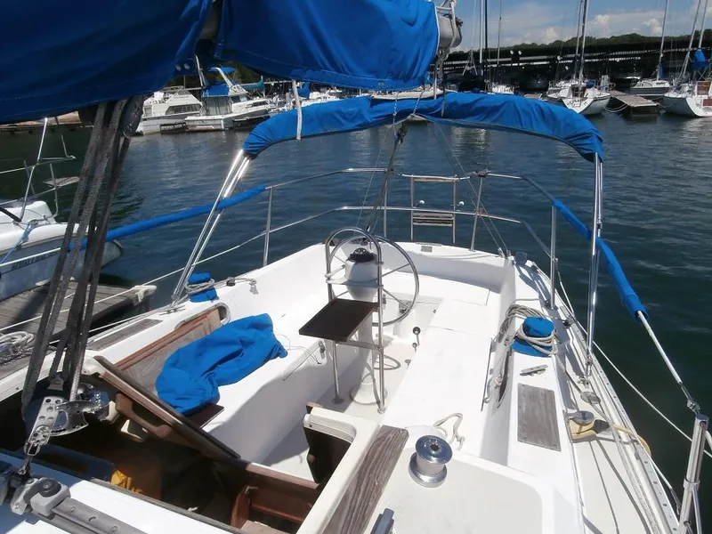 Slide: The Image of 1978 Catalina 30 sailboat with blue canopy docked in marina. - 6
