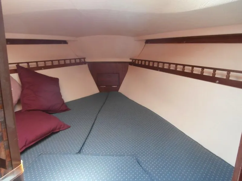 Slide: The Image of 1978 Catalina 30 sailboat interior cabin with blue cushions and maroon pillows. - 7