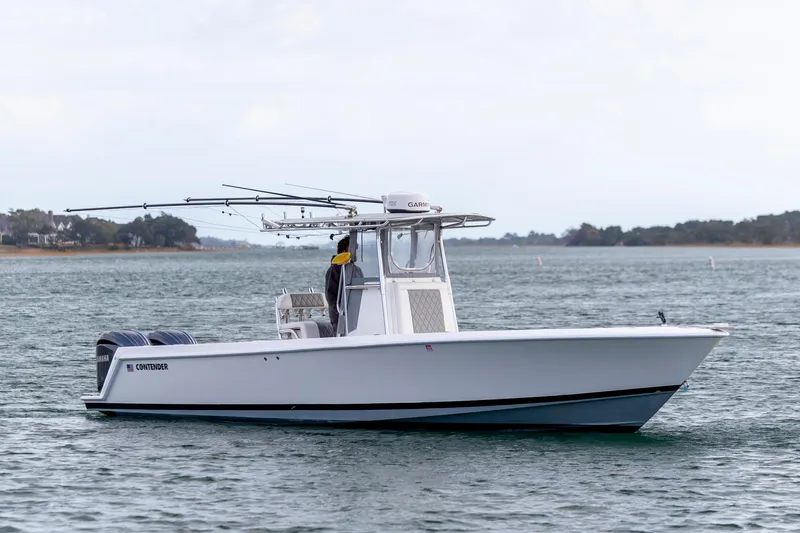 Slide: The Image of 2013 Contender 32 Tournament boat on water, equipped with dual engines and fishing rods. - 0