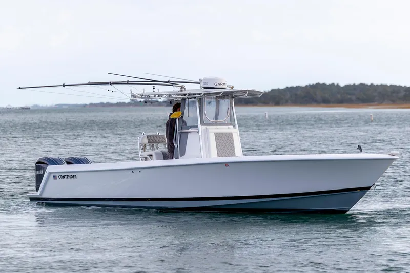 Slide: The Image of 2013 Contender 32 Tournament boat on water, equipped with fishing rods and dual engines. - 10