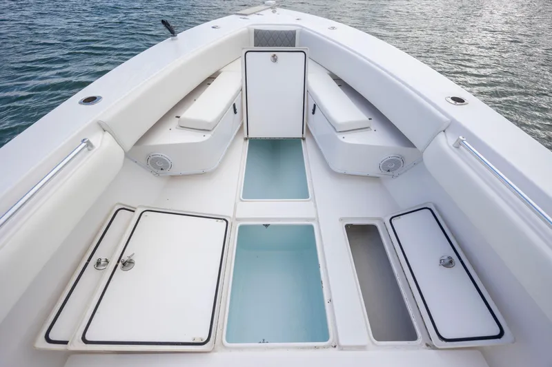 Slide: The Image of 2013 Contender 32 Tournament boat deck with storage compartments and seating, on calm water. - 14
