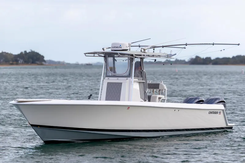Slide: The Image of 2013 Contender 32 Tournament boat on water, equipped with fishing rods and Garmin electronics. - 2