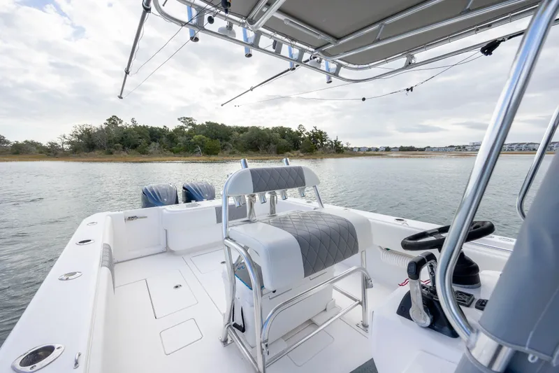 Slide: The Image of 2013 Contender 32 Tournament boat on calm water, featuring dual engines and sleek seating. - 22