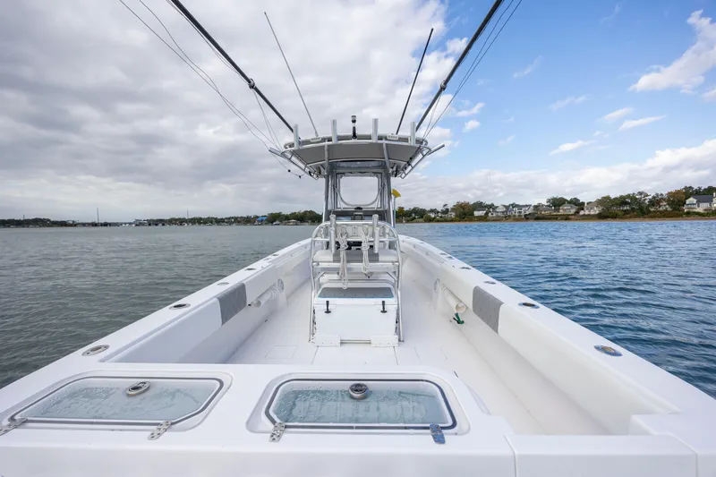 Slide: The Image of 2013 Contender 32 Tournament boat on calm water under cloudy sky. - 24