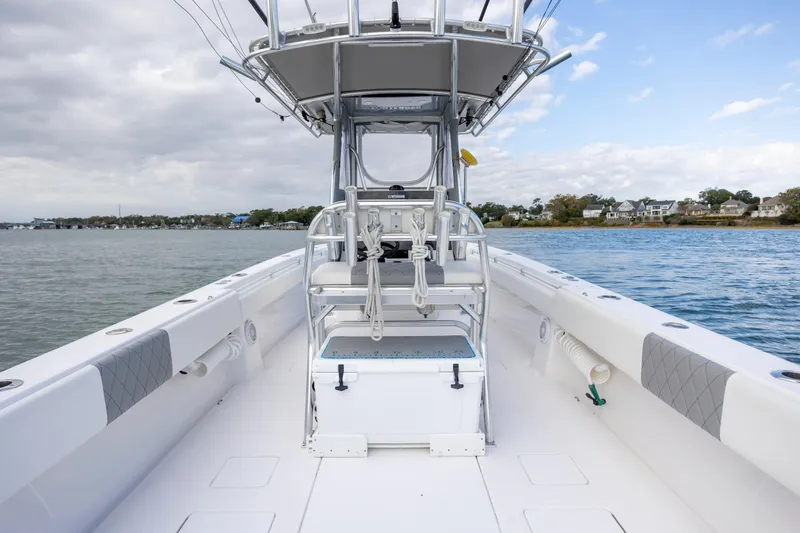 Slide: The Image of 2013 Contender 32 Tournament boat on calm water, featuring spacious deck and seating. - 25