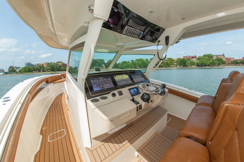 Slide: The Image of Scout 42LXF 2016: Luxurious cockpit with modern helm and leather seats, on calm water. - 24
