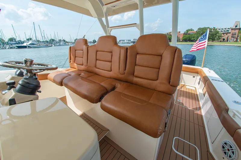 Slide: The Image of 2016 Scout 42LXF with brown leather seats and American flag in a harbor. - 26