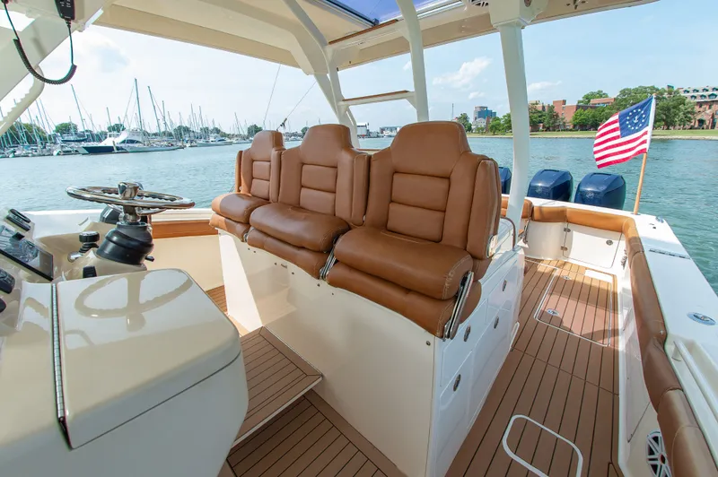 Slide: The Image of 2016 Scout 42LXF with brown leather seats and American flag in a harbor. - 27
