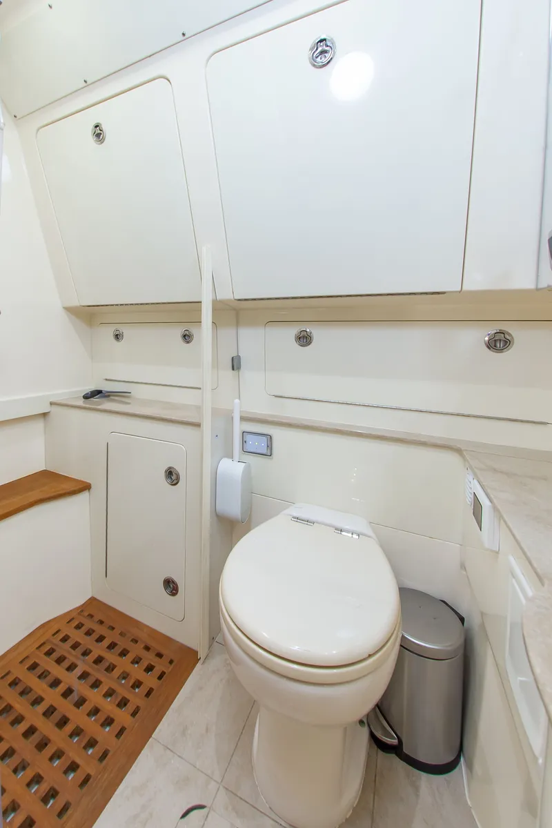 Slide: The Image of Interior of a boat cabin with a toilet and storage compartments. - 36