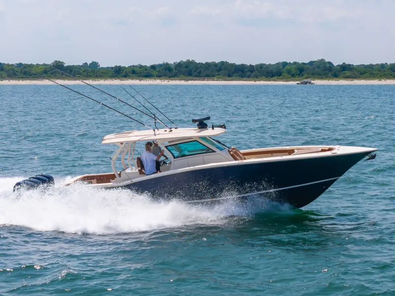 Slide: The Image of A 2016 Scout 42LXF boat speeding on the water with fishing rods. - 41