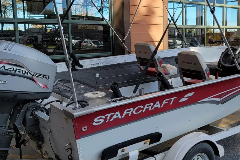 Slide: The Image of 1999 Starcraft Starfire 160 SC boat with Mariner outboard motor, parked on a trailer. - 2