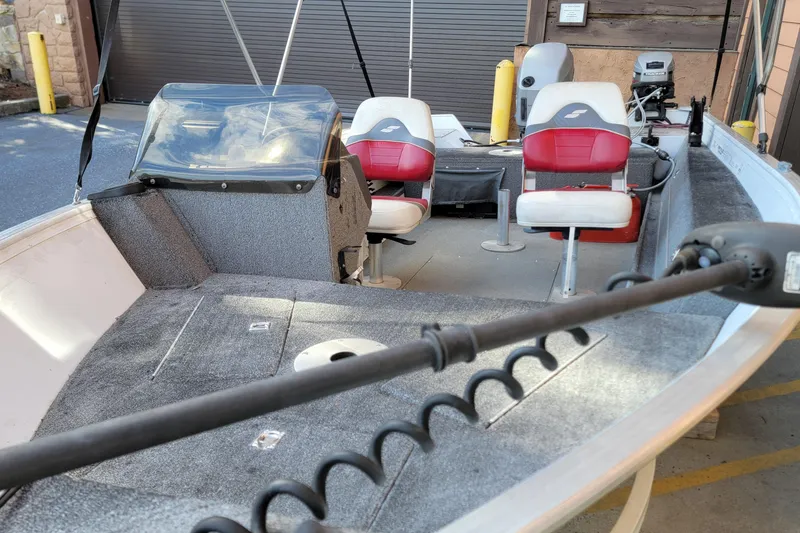 Slide: The Image of 1999 Starcraft Starfire 160 SC boat interior with red and white seats, steering console, and motor. - 8