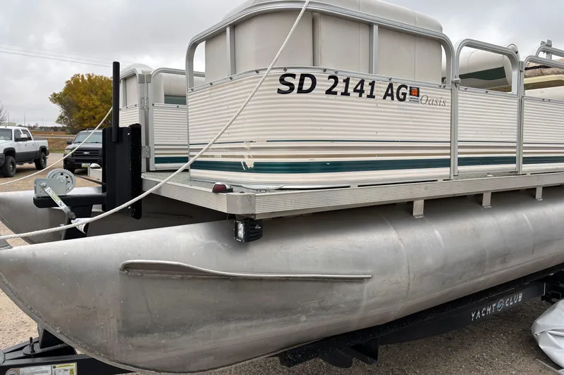 Slide: The Image of 2003 Smoker Craft Oasis pontoon boat on trailer, parked outdoors. - 3