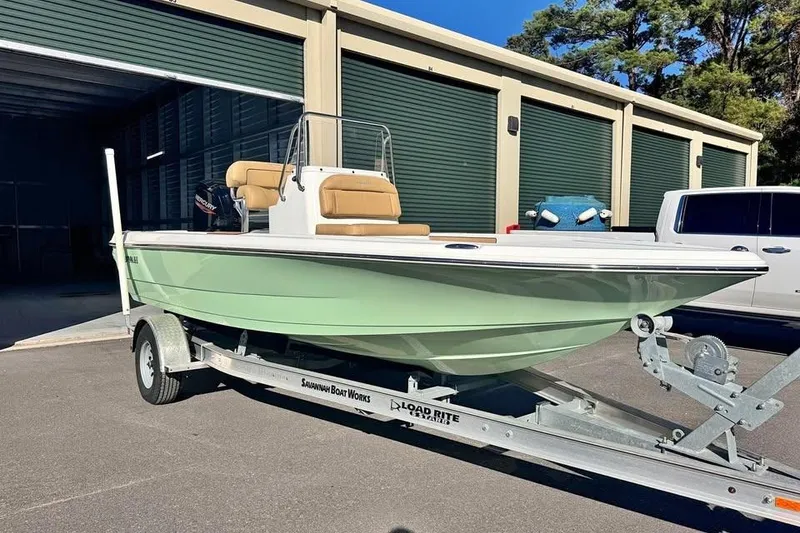 Slide: The Image of 2025 Savannah 190 IS boat on trailer, parked outside storage facility. - 13