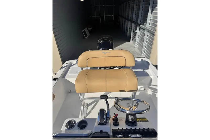 Slide: The Image of 2025 Savannah 190 IS boat interior with tan seating and steering wheel in storage. - 7