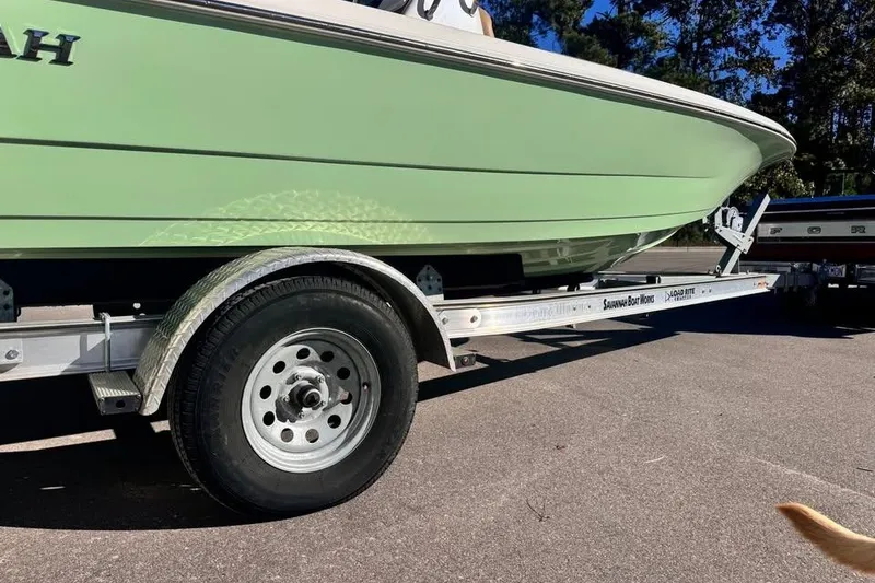 Slide: The Image of 2025 Savannah 190 IS boat on trailer, green hull, parked outdoors. - 8