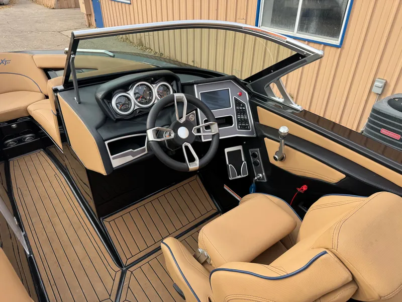 Slide: The Image of Interior of a 2021 MasterCraft XT23 boat with steering wheel and dashboard. - 19