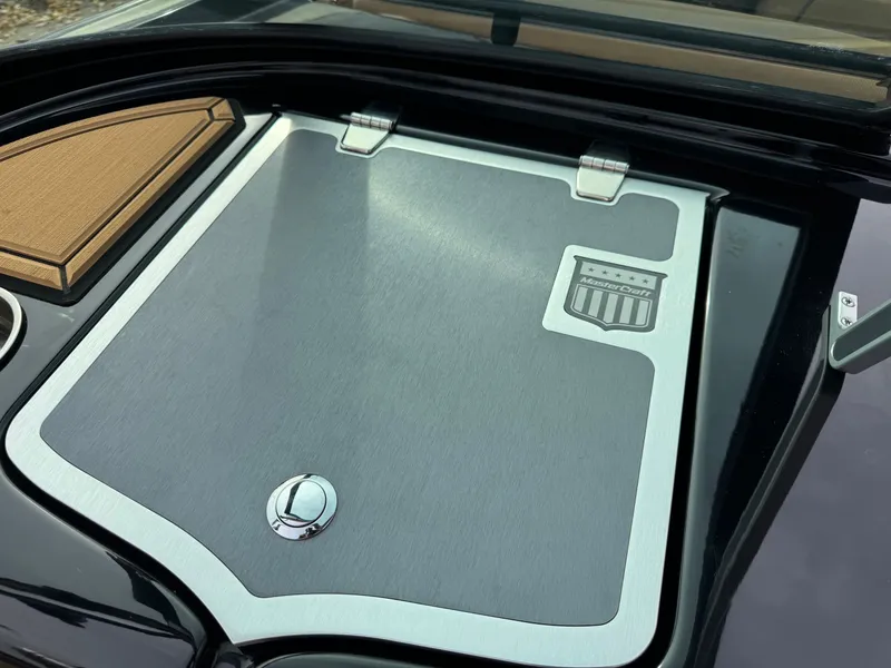 Slide: The Image of MasterCraft XT23 2021 boat hatch with logo and wood trim. - 20