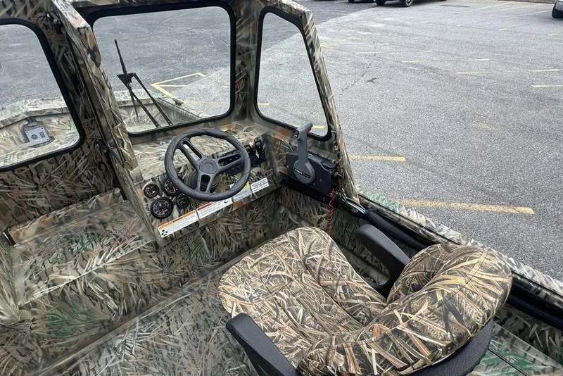 Slide: The Image of 2026 SeaArk 1872 MVJT boat interior with camouflage design, featuring steering wheel and controls. - 11
