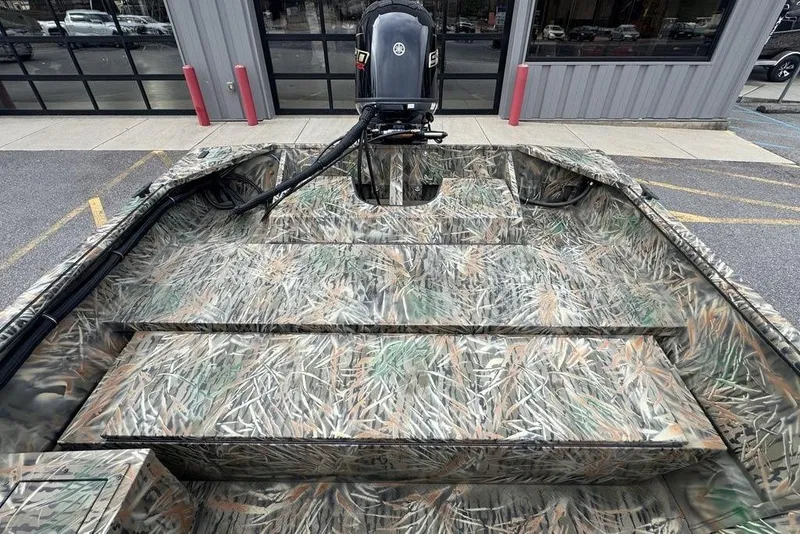 Slide: The Image of 2026 SeaArk 1872 MVJT boat with camouflage design, parked outdoors. - 15