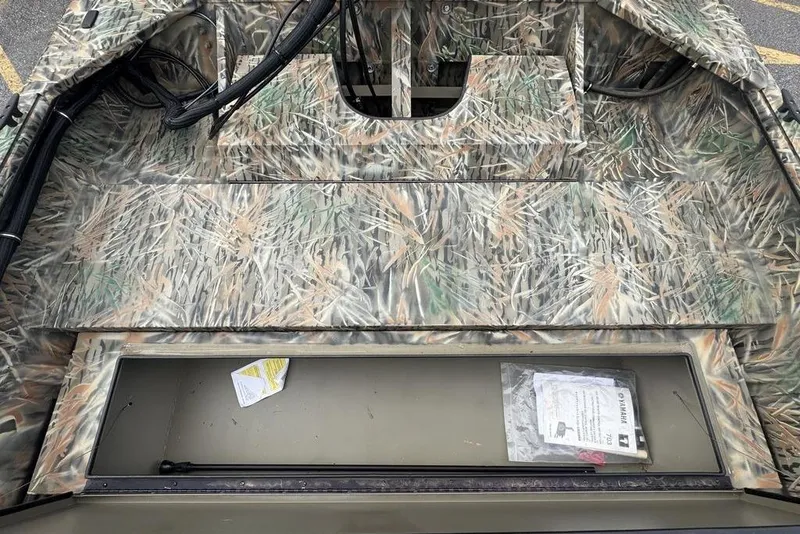 Slide: The Image of 2026 SeaArk 1872 MVJT boat interior with camouflage design and storage compartment. - 7