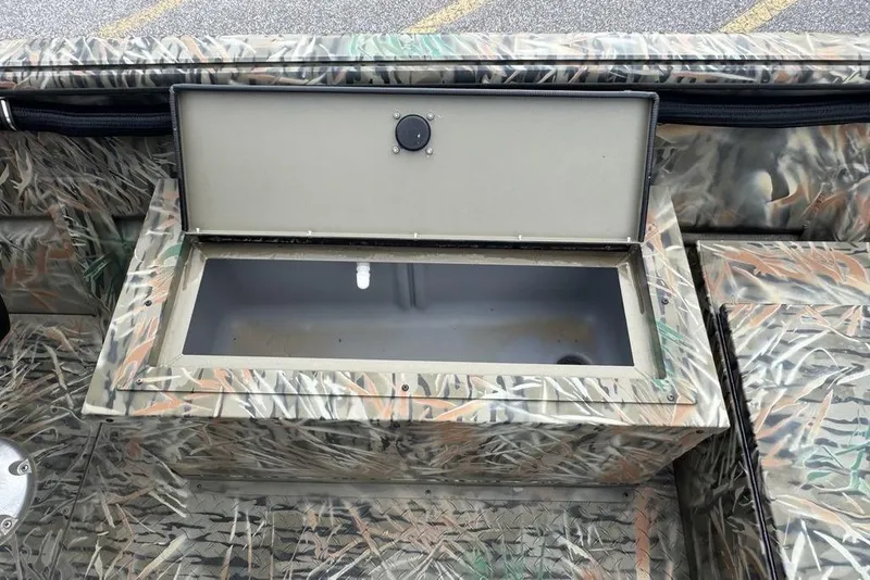 Slide: The Image of 2026 SeaArk 1872 MVJT boat with open storage compartment, camo design. - 9