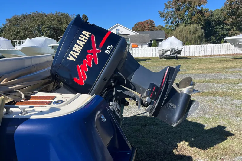 Slide: The Image of 1971 Boston Whaler 21 Outrage with Yamaha VMAX outboard motor in a yard setting. - 12