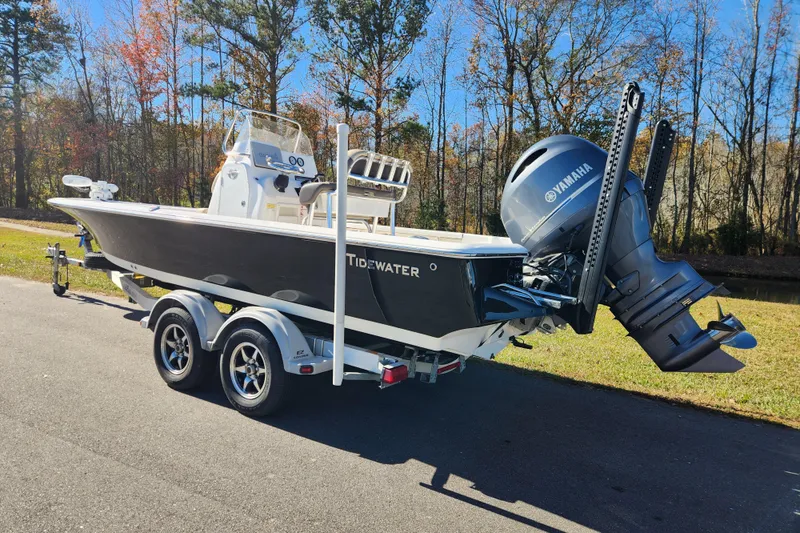 Slide: The Image of 2021 Tidewater 2110 Bay Max boat on trailer with Yamaha engine, parked outdoors. - 2