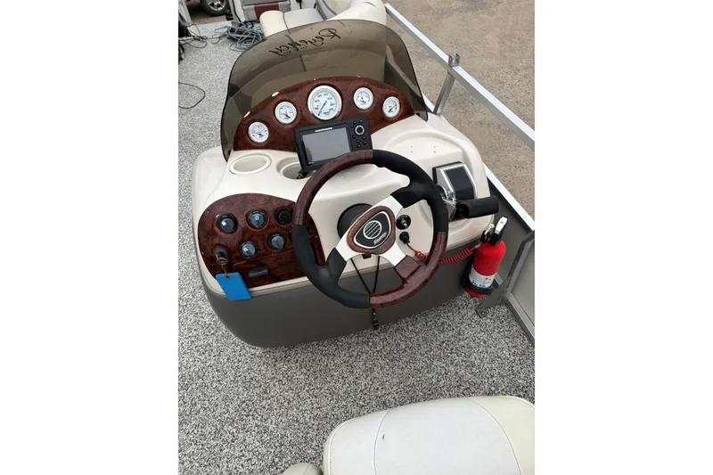 Slide: The Image of 2004 Sun Tracker Party Barge 25 I/O Regency Edition helm with steering wheel and controls. - 11